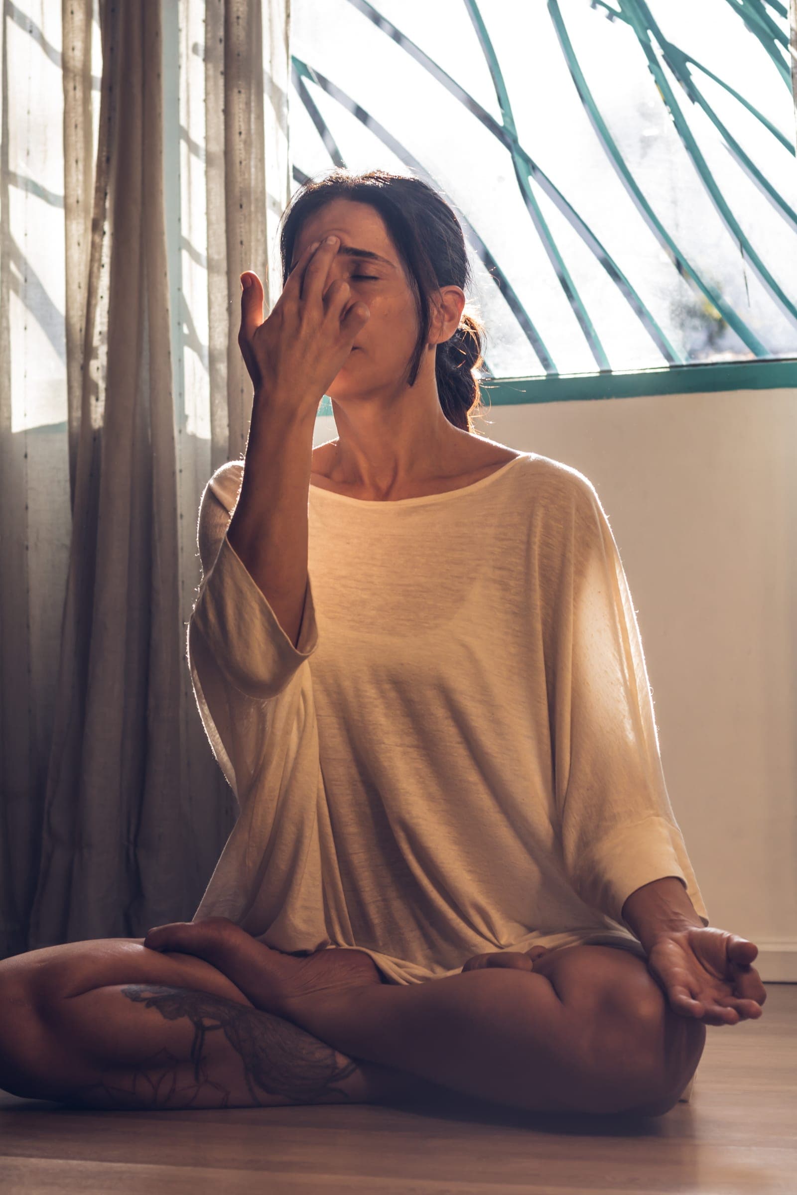 Práctica de respiración sentada junto a la ventana en is Espacio de Yoga